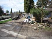 Whoever amassed this trash left a clear path for a vehicle into the side yard and off-loaded it on both sides.