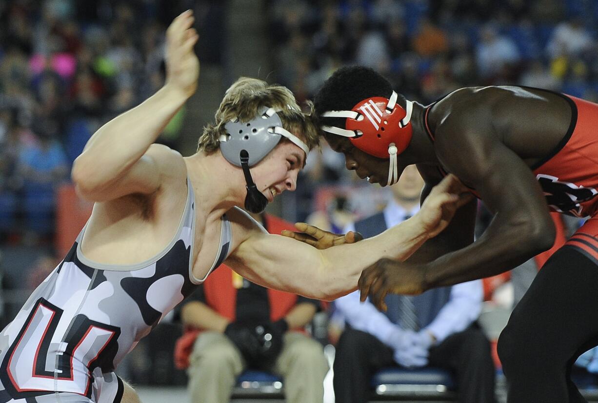 Union's Alex Berfanger, left, battles Emmanuel Daigbe of Kent-Meridian in 182-pound final of the 4A state wrestling championships in Tacoma on Saturday.