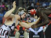 Union's Alex Berfanger, left, battles Emmanuel Daigbe of Kent-Meridian in 182-pound final of the 4A state wrestling championships in Tacoma on Saturday.