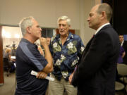 Marc Boldt, left, chats with Michael Langsdorf of Vancouver and Clark County Auditor Greg Kimsey, right, at the county Public Service Center Tuesday night.