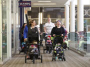 Vancouver moms Reagen Darling, left, and Shelly Stafford walk a lap around the Westfield Vancouver mall during a recent Barbells and Bottles class.