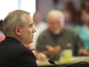 Clark County Commissioner David Madore listens to Linda Figg, CEO of FIGG Engineering Group, at a July 22 meeting on a proposed bridge in east Clark County.