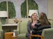 Jacquie Clemans (facing camera) catches up with hospice manager Jodi Wicks at PeaceHealth Southwest Medical Center's bereavement center on MacArthur Boulevard. Clemans is currently working through a support program to cope with the death of her husband, who suffered a heart attack while climbing Mount St.