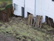 Sunday's landslide in Camas pushed a section of John Trost's backyard fence against his house.