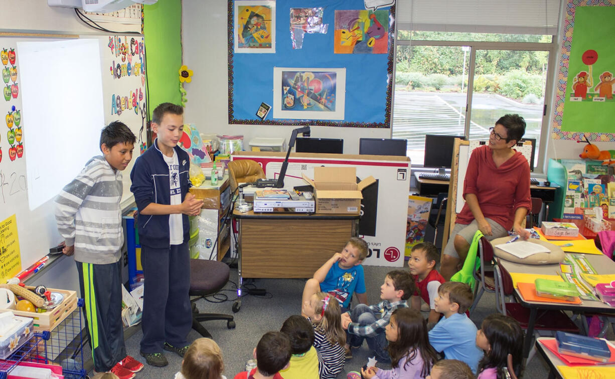 Ridgefield: South Ridge Elementary School sixth grade volunteers Fernando Jimenez, left, and Cade Bringhurst guide a younger class through story-idea brainstorming for the school's collaborative book, &quot;Eva Extraordinaire.&quot;