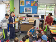 Ridgefield: South Ridge Elementary School sixth grade volunteers Fernando Jimenez, left, and Cade Bringhurst guide a younger class through story-idea brainstorming for the school's collaborative book, &quot;Eva Extraordinaire.&quot;