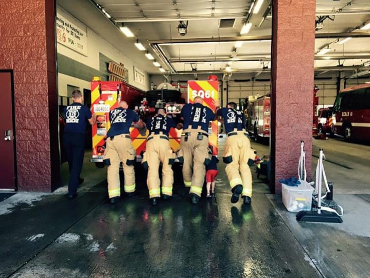 Hazel Dell: Members of Clark County Fire District 6 push the new Squad 61 fire truck into service.