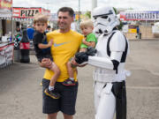 A Stormtrooper poses with Jason Beatty and his sons Ryan, 3 and Derek, 1 at the Clark County Fair on Saturday.