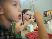 Siblings Chance 8, left, and Ashton Kalahan, 12, eat a free spaghetti lunch Wednesday at Fruit Valley Elementary School in Vancouver.