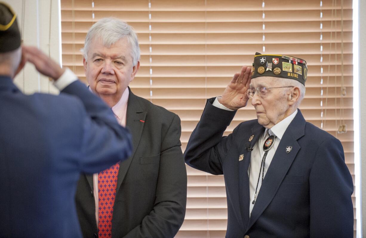 World War II veteran Fern Shaw, right, salutes Thursday in Washougal as he gets a Legion of Honor award from Jack Cowan, a French representative in Washington.