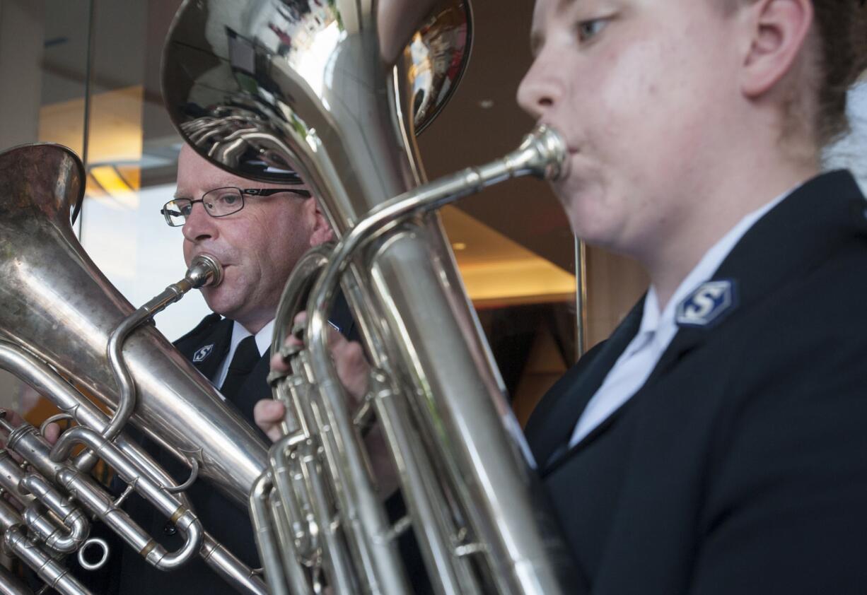 Kaylie Klicke, right, and her father, Ward Klicke, play instruments at a celebration of The Salvation Army's 125th anniversary.