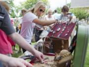 At the Recycled Arts Festival on Sunday, Sara Turner of Vancouver, center, looks at jewelry made from recycled items.