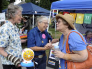 Adina Tarpley, left, and Carole Elizabeth, who have been together for 25 years, greet Lee Kendel, right, at this year's Saturday in the Park Pride event.