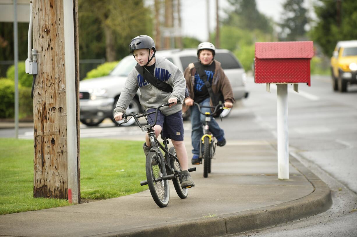 Friends Gary McCulley, 11, left, and Wyatt Varashupe, 10, ride their bikes to Walnut Grove Elementary School on Wednesday morning. The boys typically walk to school but decided to ride their bikes for National Bike to School Day.