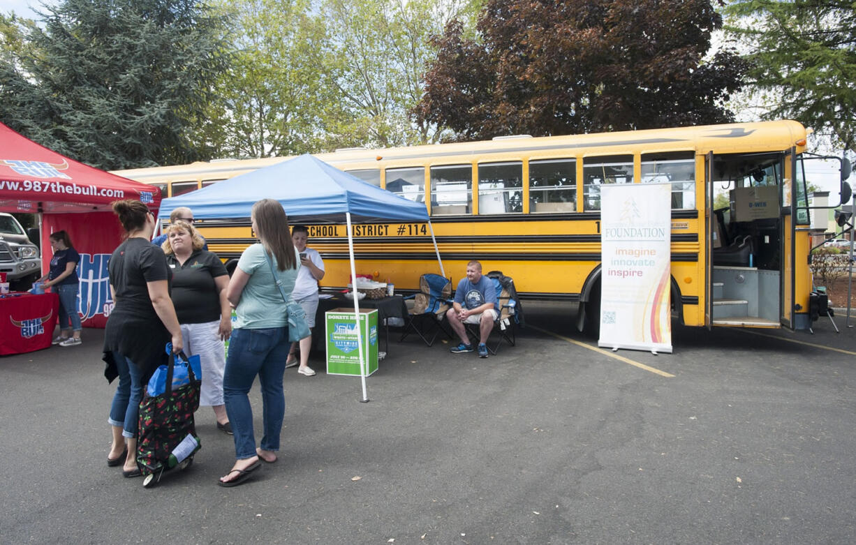 Mariah Bilby and her mother-in-law Diana Bilby donate school supplies at Stuff the Bus event at the Fisher's Landing Burgerville on Thursday.