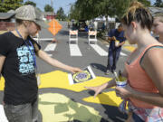 Ariane Kunze/The Columbian
Discovery Middle School art teacher Miranda Wakeman (left) and Haven Rinehart, 12, review plans for a street mural at the corner of East 33rd and R streets in Rose Village. The attention-getting mural is meant to discourage drivers from speeding through the neighborhood.