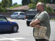 Paul Erickson, 40, stands at Northeast 81st Street and Hazel Dell Avenue with a sign that reads u201cHomeless anything helpsu201d while panhandling.