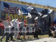 Patricia Quatier, center, watches as 51 white doves are released during Thursday's dedication of the Korean War mural on the downtown Remembrance Wall just south of City Hall.