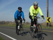 Glenn Teague, in front, followed by Dale Meier ride down Lower River Road from Frenchman's Bar Park Monday.