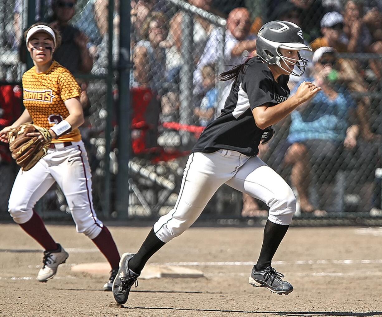 Woodland's Sidra Malik takes off after the throw flew over White River first baseman Megan Vandegrift. Between the bunt and the following overthrows, Malik ended up scoring on the play in their 2A semifinal game at Selah.