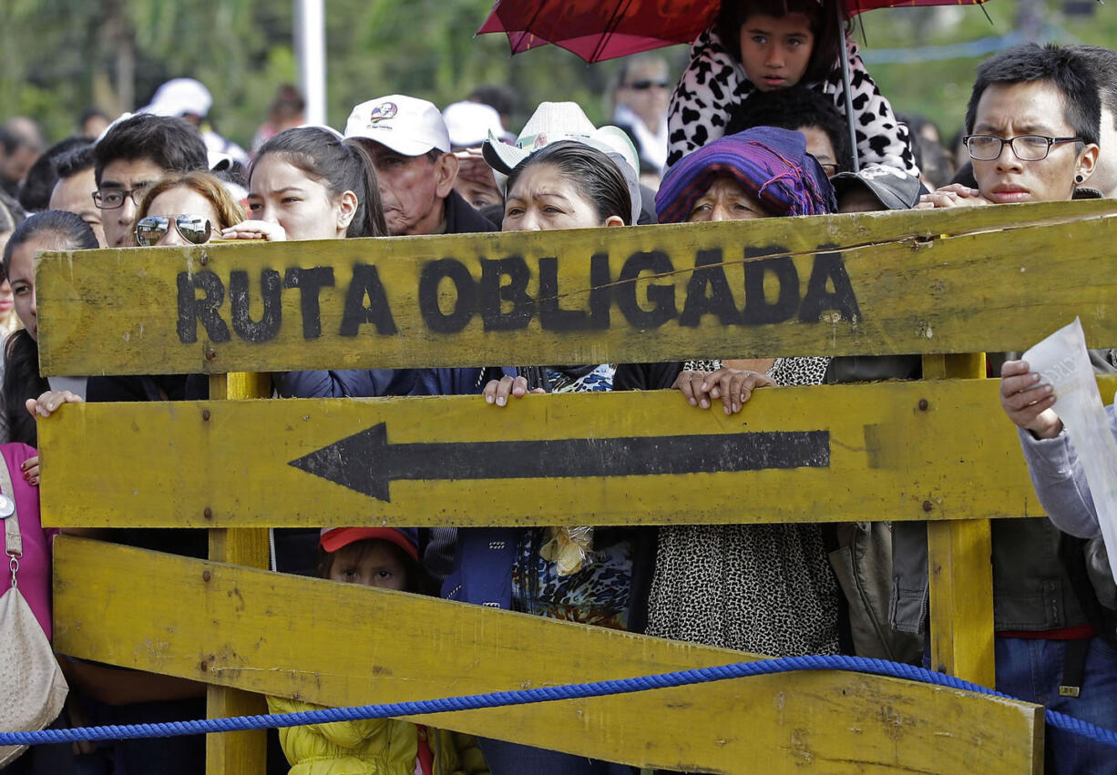 Faithful stand behind a wooden sign with a message that reads in Spanish; &quot;Obligatory route&quot; as they wait for Pope Francis to arrive and celebrate Mass at Christ the Redeemer square in Santa Cruz, Bolivia, on Thursday.