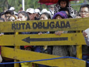 Faithful stand behind a wooden sign with a message that reads in Spanish; &quot;Obligatory route&quot; as they wait for Pope Francis to arrive and celebrate Mass at Christ the Redeemer square in Santa Cruz, Bolivia, on Thursday.