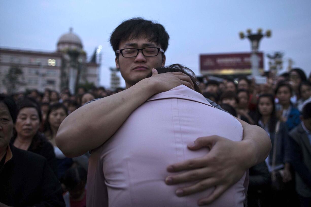 Chinatopix via AP
Relatives of passengers onboard the capsized cruise ship Eastern Star comfort each other during a candlelight vigil Thursday in Jianli county, China.