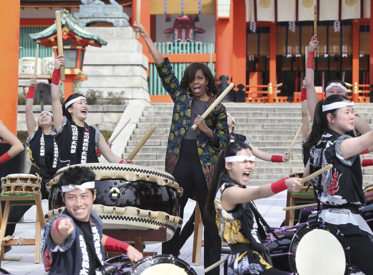 U.S. first lady Michelle Obama plays the taiko drum with the Akutagawa High School Taiko Club members Friday during her visit to Fushimi Inari Shinto Shrine in Kyoto in western Japan. Taiko drums are a broad range of Japanese percussion instruments and originate in Japanese folklore.