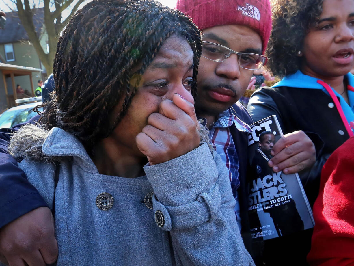 Kyrisha Isom, left, weeps with Derrick McCann during a protest Saturday in Madison, Wis., against the shooting death of Tony Robinson, 19, who was fatally shot late Friday by a police officer.