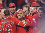 Los Angeles Angels' Carlos Perez, center, is surrounded by teammates after hitting a walk-off home run to beat the Seattle Mariners 5-4 in the ninth inning of a baseball game Tuesday, May 5, 2015, in Anaheim, Calif. (AP Photo/Mark J.