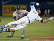 Toronto Blue Jays' Kevin Pillar, right, makes a diving attempt but gets tagged out at first base by Seattle Mariners first baseman Logan Morrison during the ninth inning in Toronto on Friday, May 22, 2015.