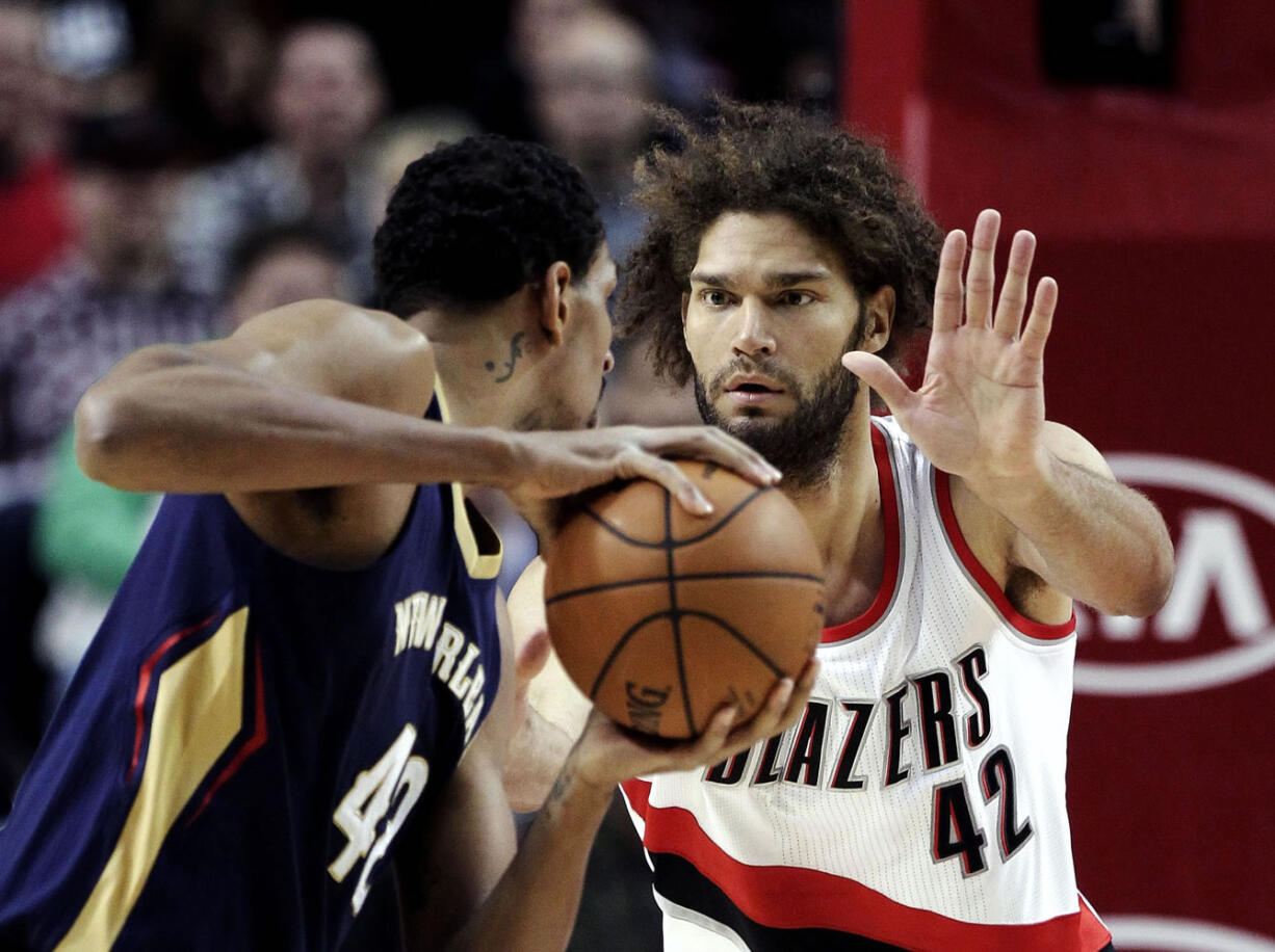 New Orleans Pelicans center Alexis Ajinca, from France, looks to maneuver against the defense of Portland Trail Blazers center Robin Lopez during the first half Monday, Nov. 17, 2014.