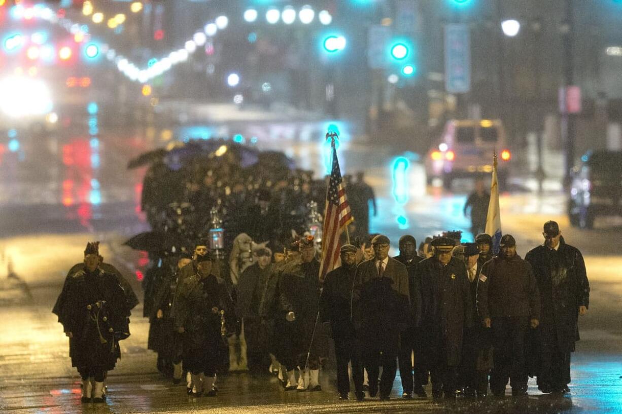 Philadelphia Police Officer Robert Wilson III's funeral procession marches along Market Street during a winter rainstorm on Saturday in Philadelphia.