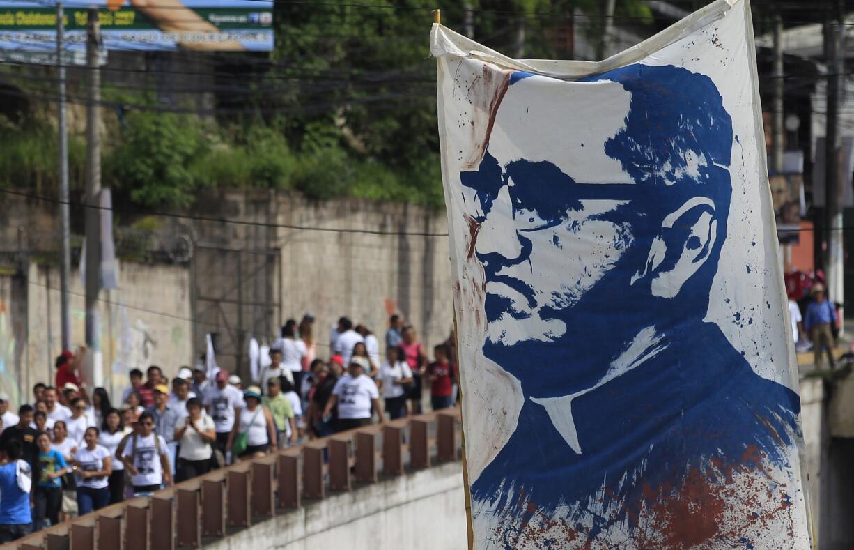 Pilgrims carry a portrait of Roman Catholic Archbishop Oscar Romero to Romero's beatification ceremony in San Salvador, El Salvador, Saturday, May 23, 2015. Romero was beatified by Roman Catholic officials in a ceremony elevating the once-controversial cleric to the ranks of the blessed 35 years after his assassination.