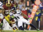 Seattle Seahawks wide receiver Percy Harvin (11) carries the ball past Washington Redskins inside linebacker Perry Riley (56) during the first half of an NFL football game in Landover, Md., Monday, Oct. 6, 2014.