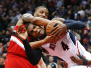 Atlanta Hawks forward Paul Millsap (4) and Portland Trail Blazers guard Damian Lillard struggle for the ball during the second half of an NBA basketball game Friday, Jan. 30, 2015, in Atlanta.