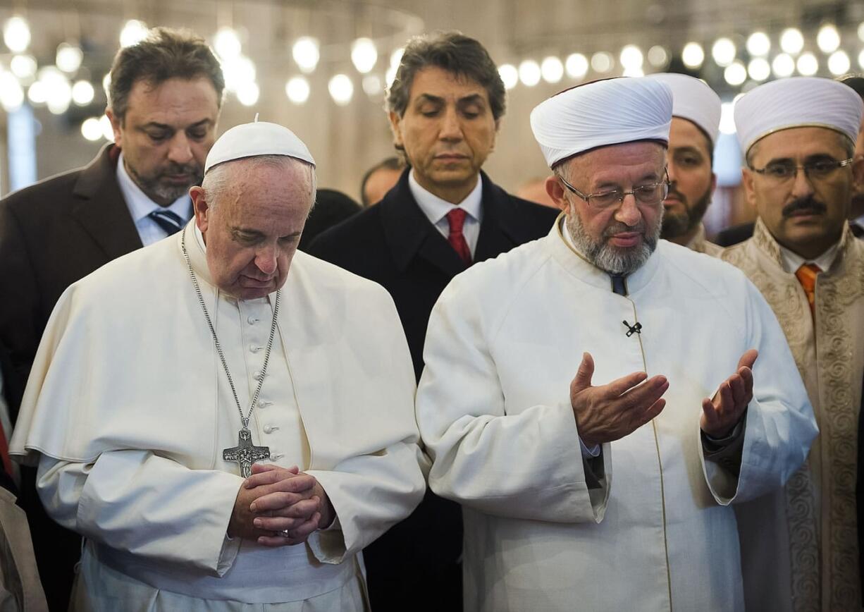 L'Osservatore Romano/Associated Press
Pope Francis, front left, joins Grand Mufti of Istanbul, Rahmi Yaran, in prayer Saturday in the Sultan Ahmet mosque in Istanbul, Turkey.