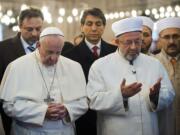 L'Osservatore Romano/Associated Press
Pope Francis, front left, joins Grand Mufti of Istanbul, Rahmi Yaran, in prayer Saturday in the Sultan Ahmet mosque in Istanbul, Turkey.