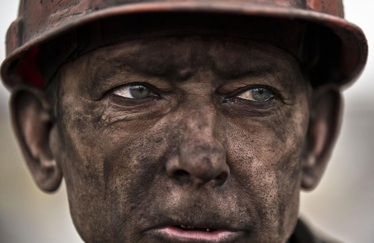 A Ukrainian coal miner waits for a bus after exiting the underground of the Zasyadko mine, where he helped search for bodies of colleagues and clear up debris following an explosion, in Donetsk, Ukraine, on Wednesday.