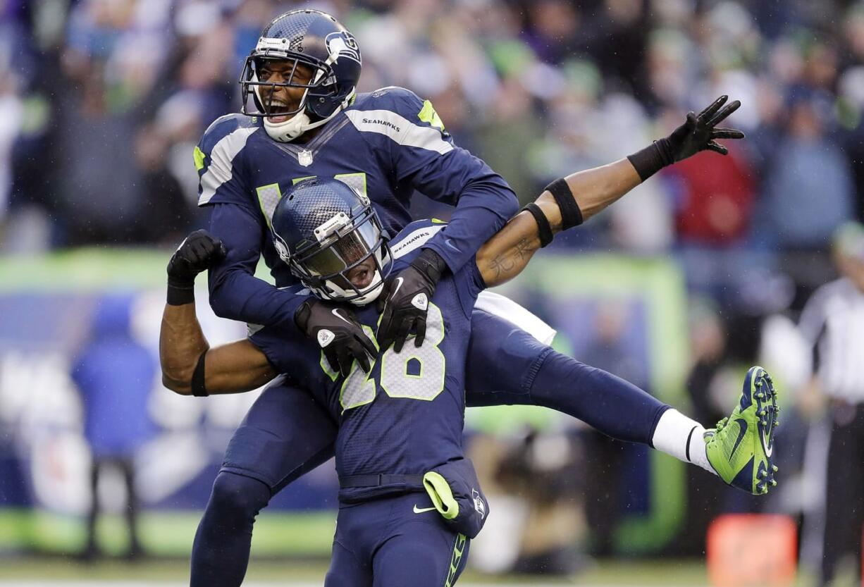 Seattle Seahawks' Byron Maxwell, top, leaps on the back of Walter Thurmond after Thurmond intercepted and scored against the Minnesota Vikings in the second half of an NFL football game Sunday, Nov. 17, 2013, in Seattle. (AP Photo/Ted S.