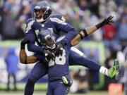 Seattle Seahawks' Byron Maxwell, top, leaps on the back of Walter Thurmond after Thurmond intercepted and scored against the Minnesota Vikings in the second half of an NFL football game Sunday, Nov. 17, 2013, in Seattle. (AP Photo/Ted S.