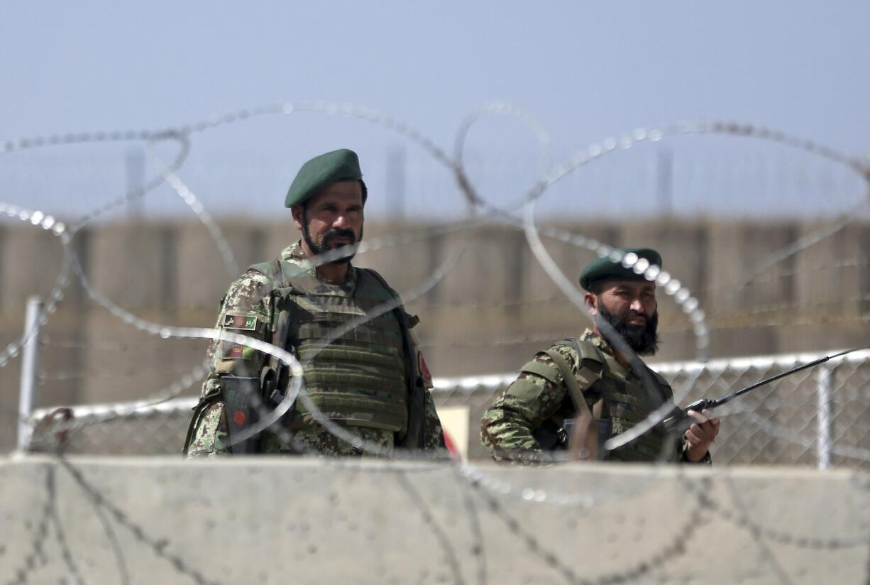 Afghanistan National Army soldiers stand guard at a gate of Camp Qargha, west of  Kabul, Afghanistan, on Tuesday.