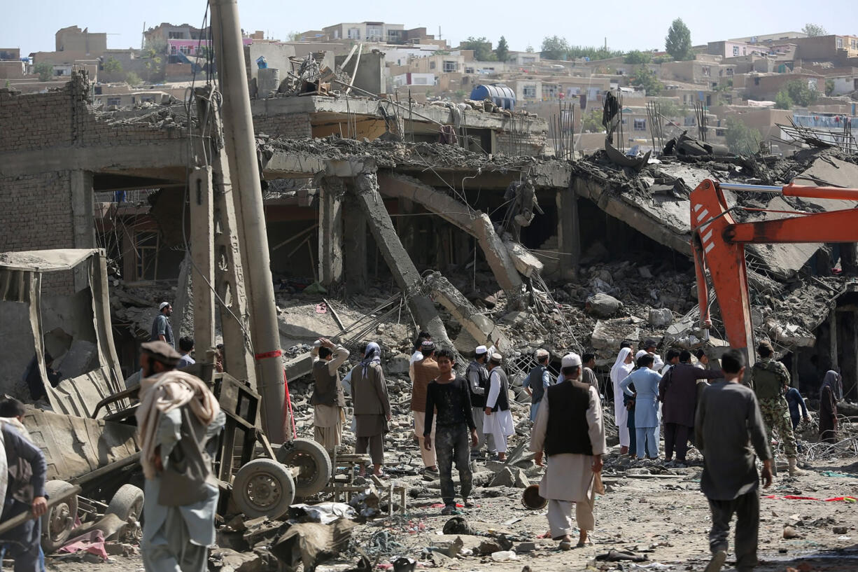 Afghan people gather Friday at the site of a car bomb attack in Kabul, Afghanistan. A bomb hidden in a truck exploded in the center of the Afghan capital, killing several people and wounding hundreds, police and health officials said Friday. Police chief Abdul Rahman Rahimi said the pre-dawn blast was near a Defense Ministry compound, but that all of the victims were civilians, including women and children.