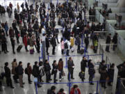 Passengers queue up for a security check at Pudong International Airport in Shanghai, China.