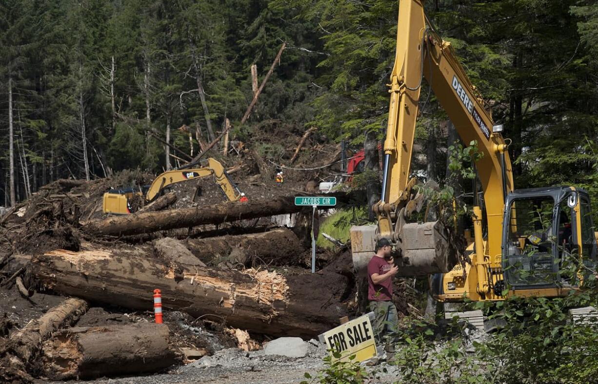 james poulson/Daily Sitka Sentinel via AP
Conner Forrey with Southeast Earthmovers walks to his excavator Friday at the site of the Kramer Avenue landslide in Sitka, Alaska.