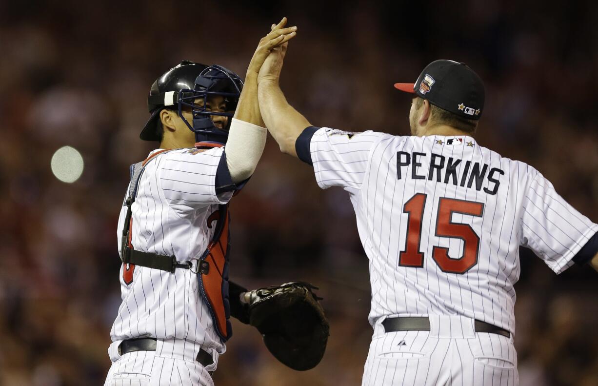 American League catcher Kurt Suzuki, of the Minnesota Twins, celebrates with American League pitcher pitcher Glen Perkins, of the Minnesota Twins, after their 5-3 victory in the MLB All-Star Game, Tuesday, July 15, 2014, in Minneapolis.