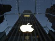 The Apple logo is illuminated in the entrance to the Fifth Avenue Apple store, in New York.