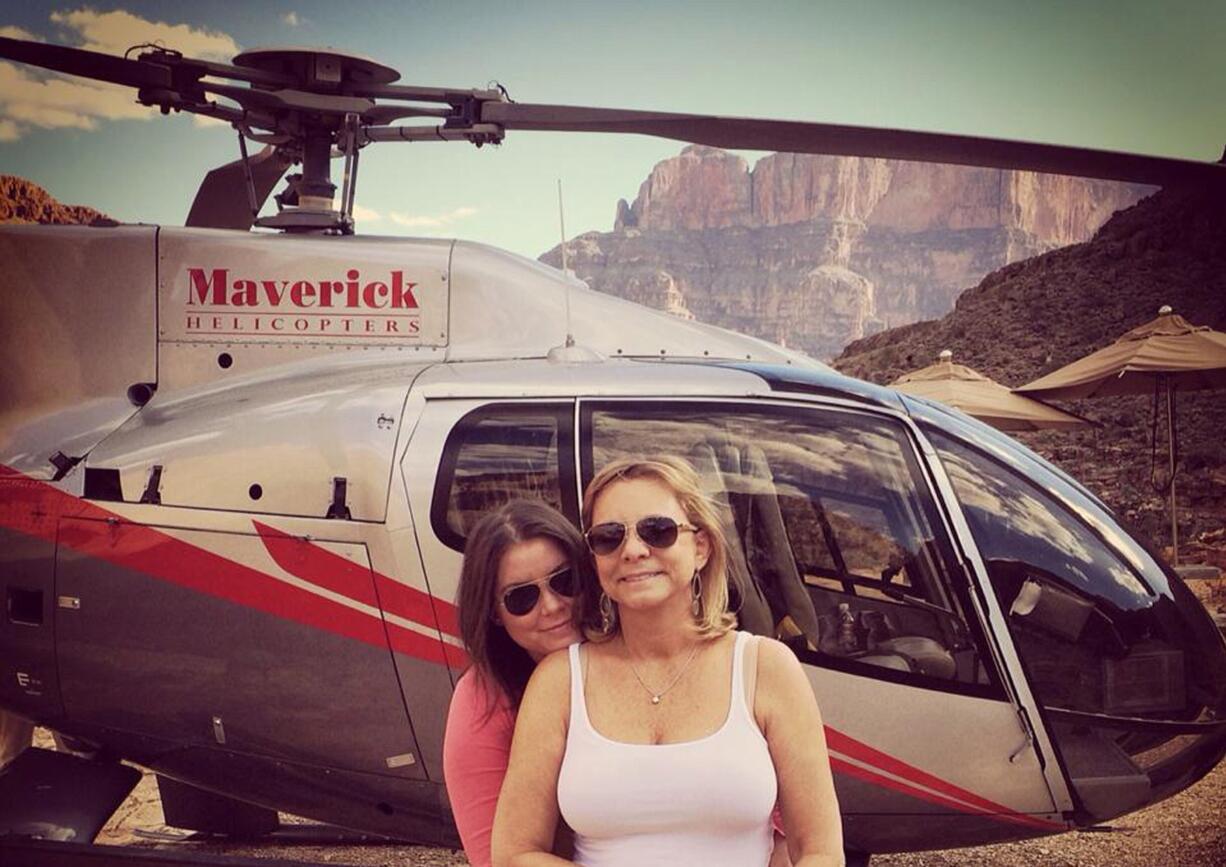 Brittany Maynard, left, hugs her mother Debbie Ziegler next to a helicopter at the Grand Canyon National Park in Arizona on Oct.