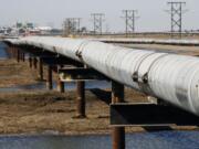 In this 2007 photo, an oil transit pipeline runs across the tundra to flow station at the Prudhoe Bay oil field on Alaska's North Slope.