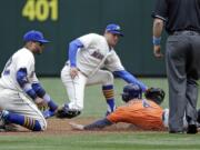 Houston Astros' George Springer (4) slides safely into second base as the ball gets past both Seattle Mariners second baseman Robinson Cano, left, and shortstop Brad Miller in the first inning Sunday, June 21, 2015, in Seattle. Springer advanced on a wild pitch.